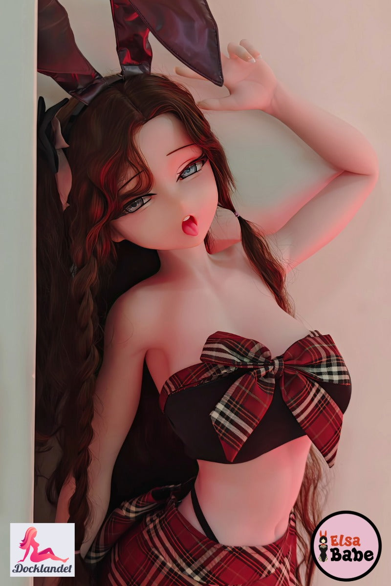 "Elsa Babe 140 cm anime sexdocka i silikon med stora rosett-detaljer och svarta kaninöron, poserar i rutigt set."